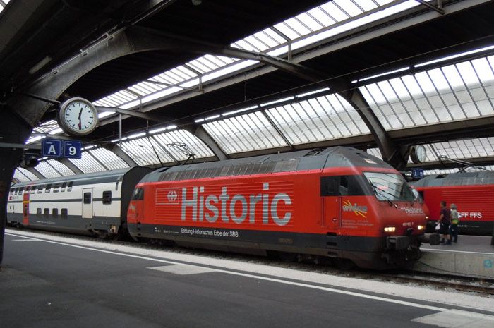 La Fundacin que gestiona los trenes histricos de los Ferrocarriles federales suizos, pasea este enorme logo en los laterales de la 460-102 en la estacin de Zrich con un tren regional de dos pisos.